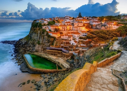 Azenhas do Mar cliffside village in Sintra, Portugal, with natural ocean pool and houses overlooking the Atlantic.