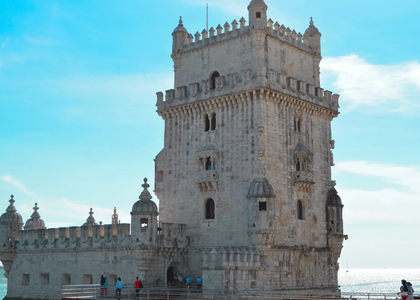 The Belém Tower in Lisbon, Portugal, a UNESCO World Heritage Site, standing by the Tagus River under a clear blue sky.