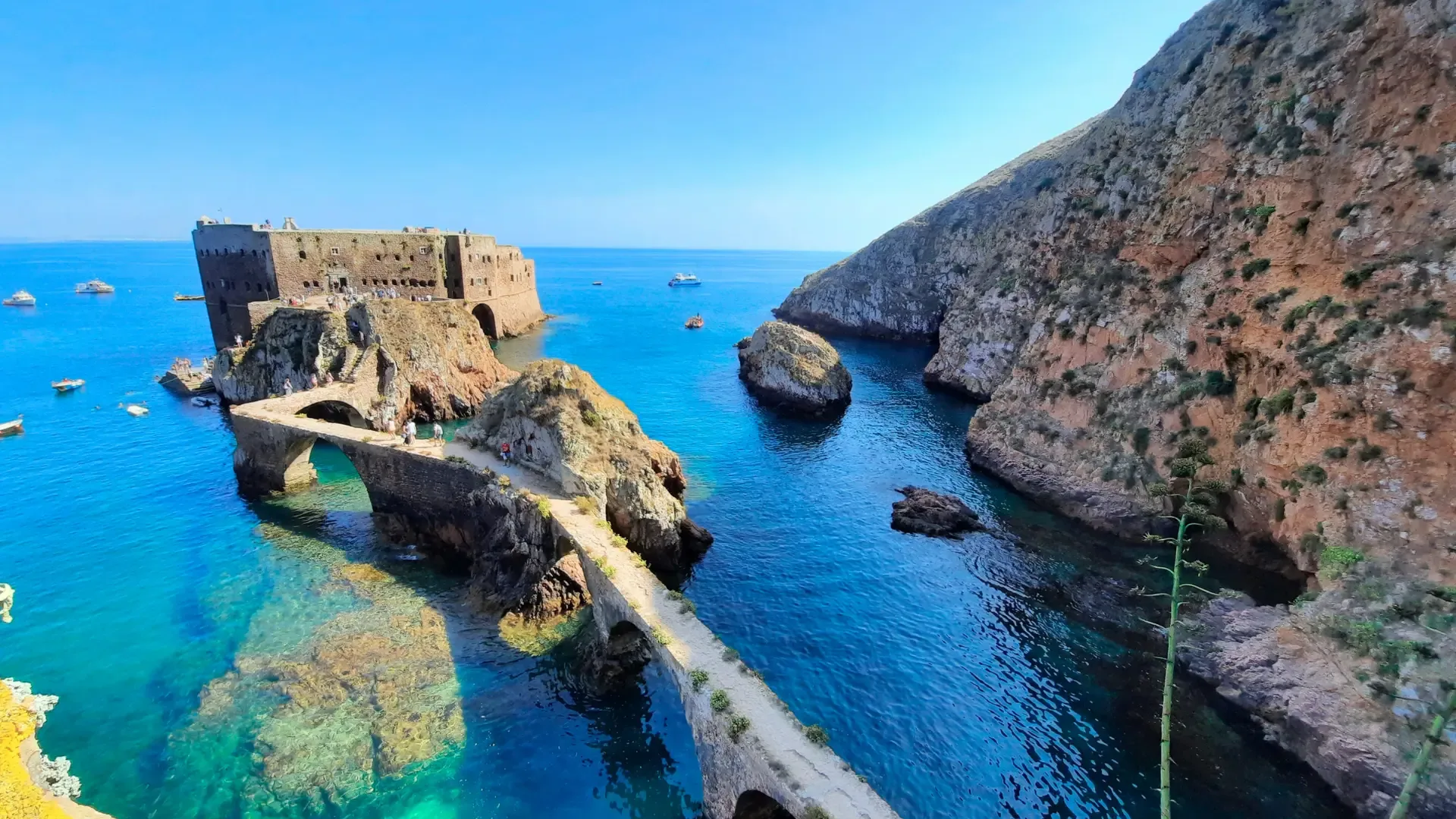 Vista do Forte de São João Baptista ligado à ilha por uma ponte de pedra sobre águas cristalinas nas Ilhas Berlengas, Portugal.