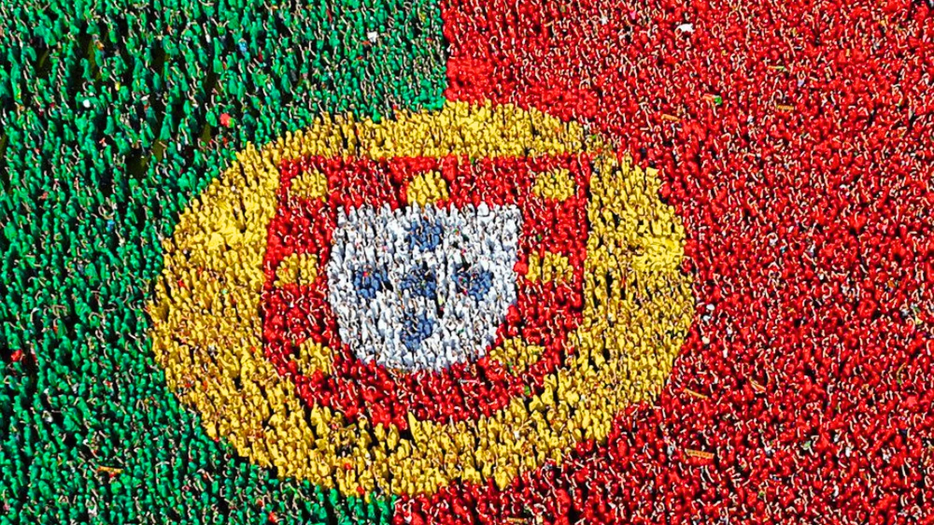 Aerial view of thousands of people forming a giant Portuguese flag in Viana do Castelo, breaking a world record for the largest human flag.
