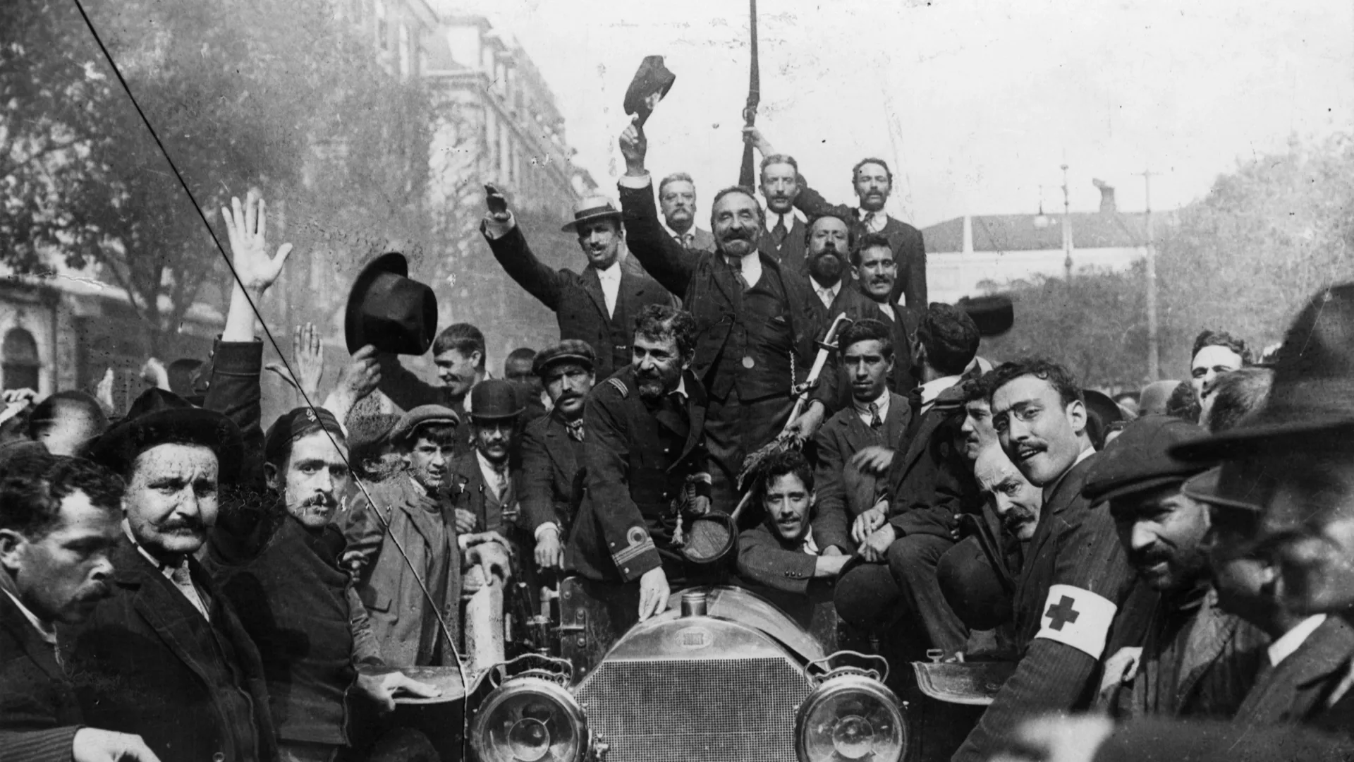 Portuguese citizens celebrating the proclamation of the Republic in 1910. Afonso Costa and other republican leaders are seen surrounded by a crowd in Lisbon, marking the end of the monarchy.
