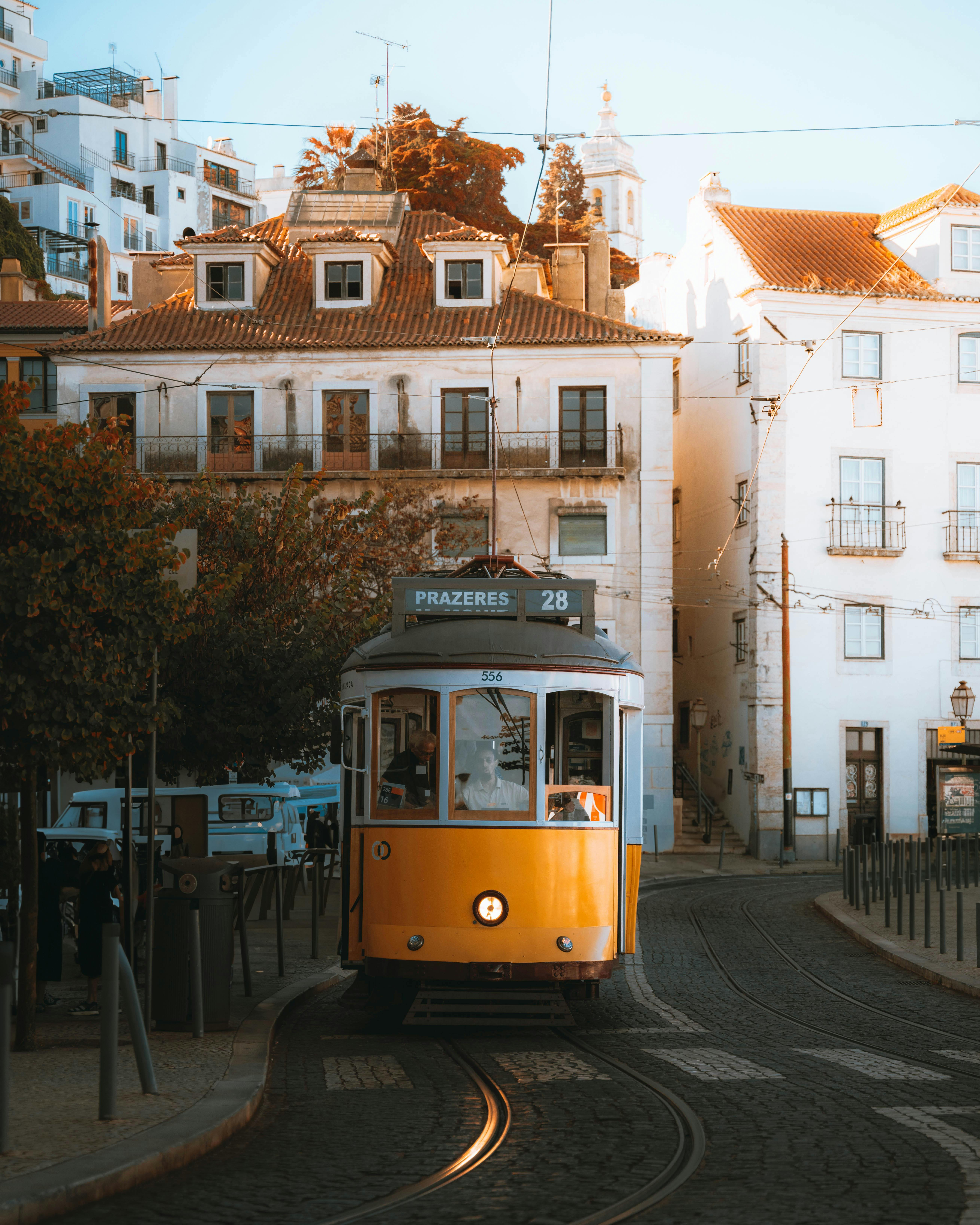 Famous yellow Tram 28 riding through Alfama’s cobbled streets in Lisbon