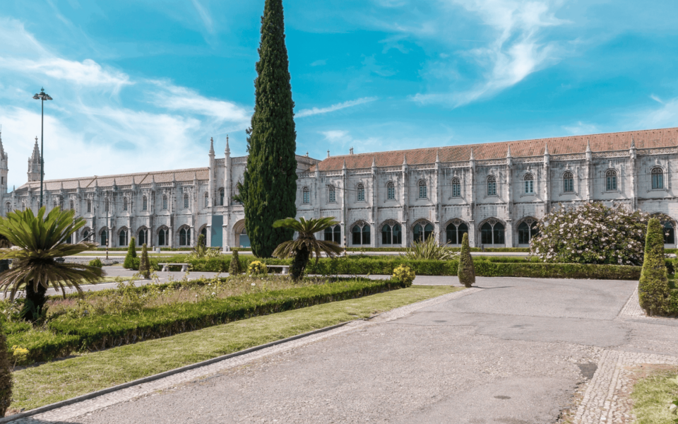 Panoramic view of the Jerónimos Monastery and the landscaped gardens in Belém, Lisbon. The Manueline-style architecture and well-kept paths highlight this UNESCO World Heritage Site in Portugal.