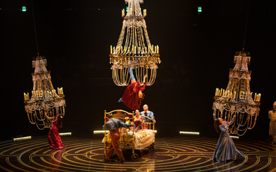 Cirque du Soleil acrobats performing in Corteo with hanging chandeliers above the stage