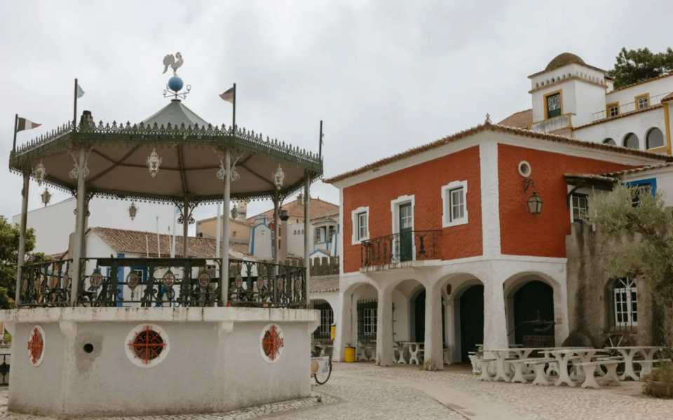 Traditional Portuguese village scene at José Franco’s miniature village in Sobreiro, featuring a red house and an ornate bandstand in the main square.