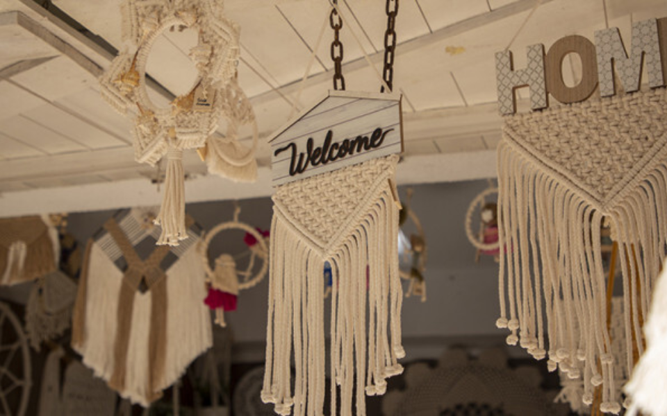 Macramé crafts with “Welcome” and “Home” signs on display at FIARTIL fair