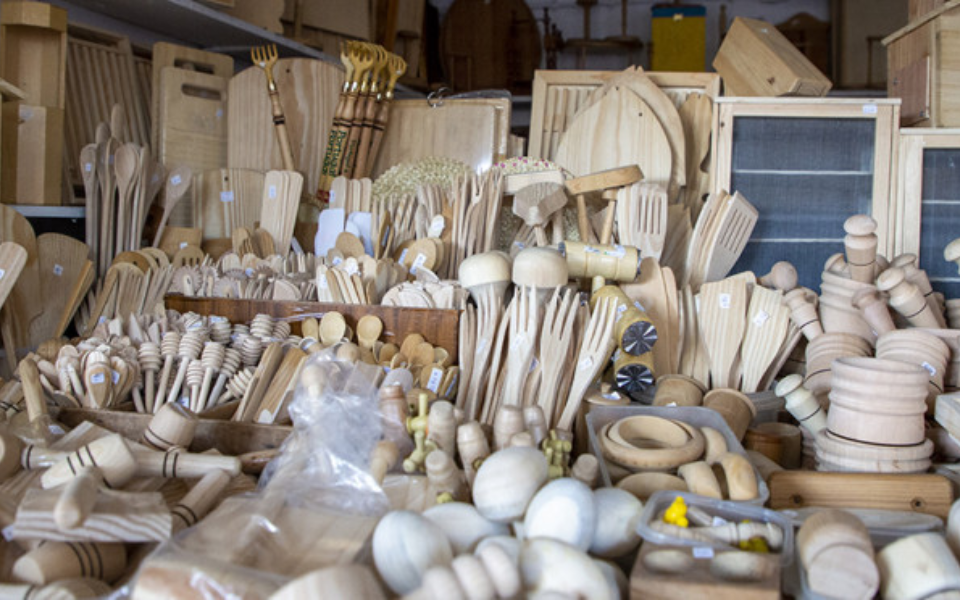 Table filled with handmade wooden items and tools at the FIARTIL fair
