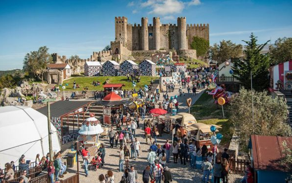 Visitors at the Óbidos Chocolate Festival with the medieval castle in the background