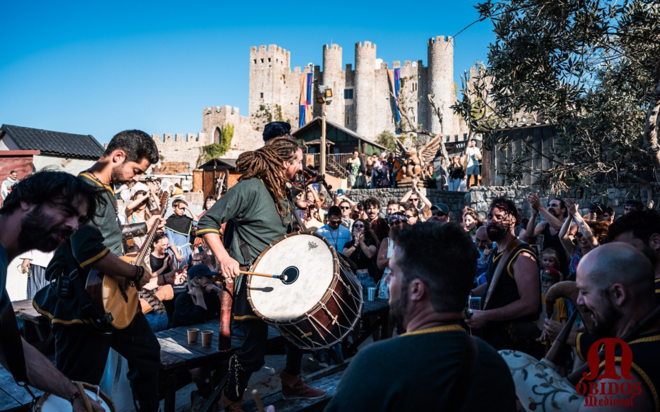 Musicians playing medieval instruments entertaining the crowd near Óbidos castle