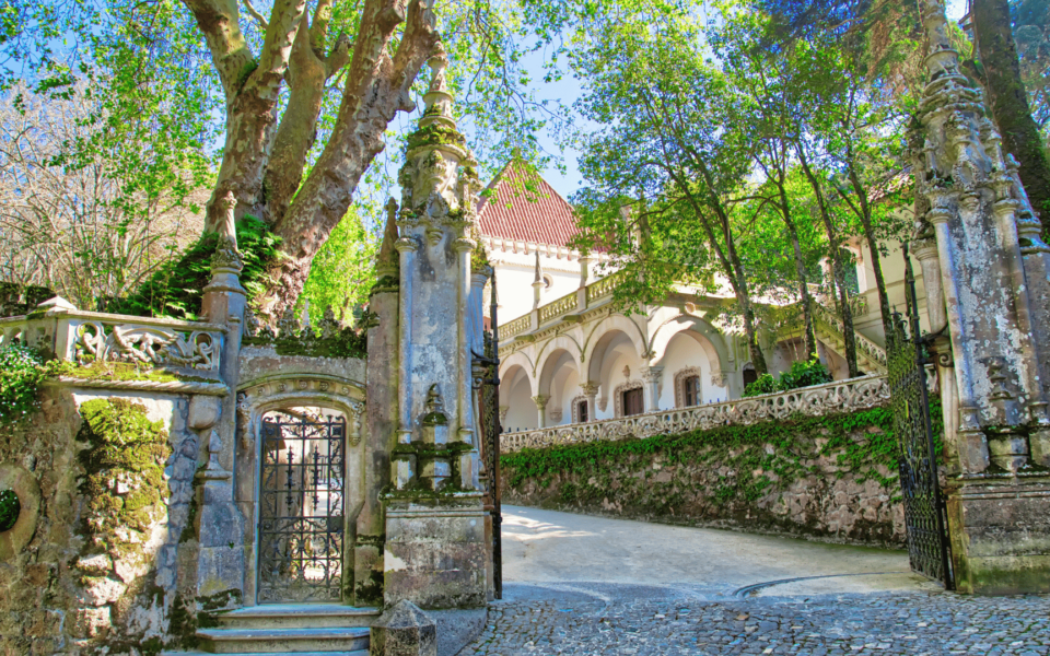 Spiral view of the Initiation Well at Quinta da Regaleira in Sintra, Portugal, showcasing its mystical architecture and moss-covered stone walls.