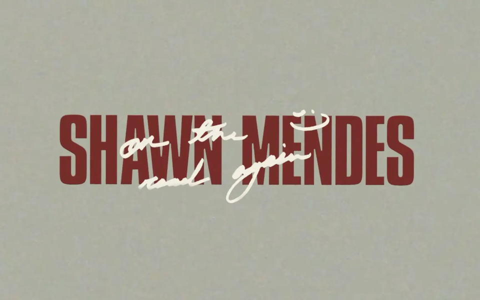 Minimalist promotional graphic with the name “SHAWN MENDES” in bold red capital letters and the handwritten phrase “on the road again” overlaid in white cursive.