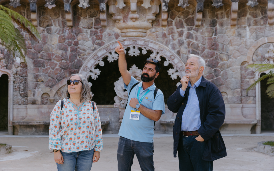 Tourists gather around a guide who highlights the amazing Quinta da Regaleira fountain.
